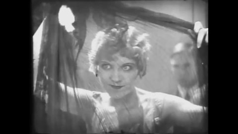 CIRCA 1928 - In this silent comedy, a flapper scandalizes party guests by showing off a black negligee.