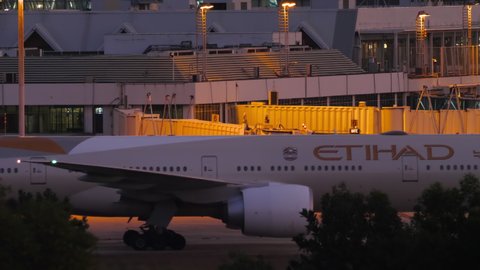 PHUKET, THAILAND - NOVEMBER 26, 2019: Side view, Boeing 777 of Etihad Airways taxiing to the terminal after landing at Phuket airport in the evening. Tourism and travel concept