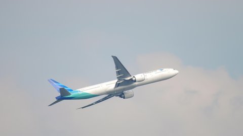 AMSTERDAM, THE NETHERLANDS - JULY 26, 2017: Boeing 777 of Garuda Indonesia take off and climb at Schiphol Airport, Amsterdam. Garuda Indonesia is the national airline of Indonesia