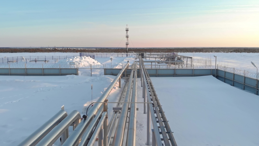 A drone flies over a pipeline, a gas pipeline at an oil and gas field in Siberia. Natural gas reserves in Russia or Canada. Rising gas prices in the world. Flight over the pipeline in winter. Royalty-Free Stock Footage #1088931463