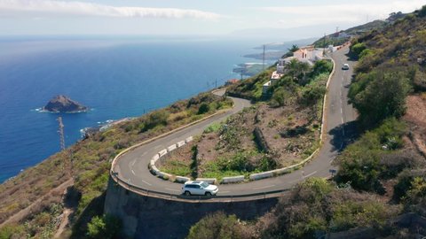 4K drone aerial shot of a winding road on a steep cliff above historical village of Garachico, above the coast of Atlantic Ocean in north Tenerife, Canary Islands