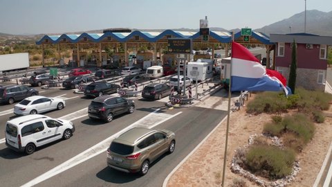 SPLIT, CROATIA - August 12 2021: Aerial view of the traffic waiting at toll booths in Dugopolje in summer time with a Croatian flag in the front.
