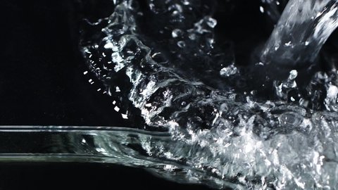 Slow motion water surface texture splash, waves and ripples on black background