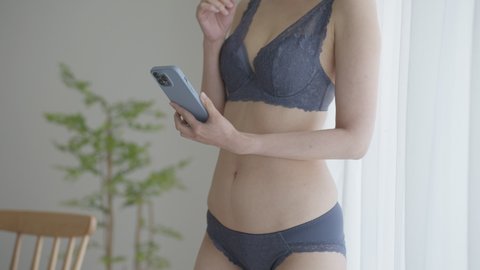 Asian woman in underwear using a cell phone