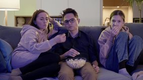 Mom, son and daughter eat popcorn and watch TV. Family watching TV.