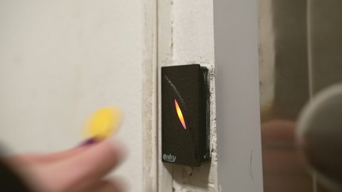 PRAGUE , CZECH REPUBLIC - MARCH 10 2022: Woman unlocks door attaching magnet key to intercom on white wall at entrance. Access control and security system in building close view