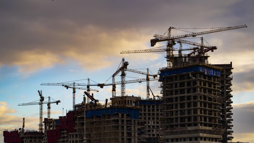 Cranes working day and night on construction of the housing estate in former industrial zone, time lapse