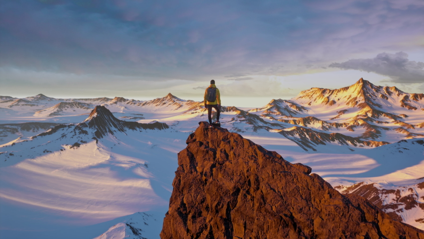 Hiker Man Standing on Top of Mountain Peak Summit at Sunset Golden Hour Conquering Fears Anxiety Stress Victory Success Concept Royalty-Free Stock Footage #1088945125