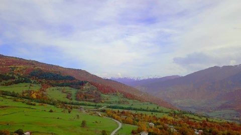 Flying on drone over autumn mountains with serpentine mountain road and forest. Georgia, Svaneti. drone flies over beautiful landscape autumn colorful forest, dangerous road for professional drivers