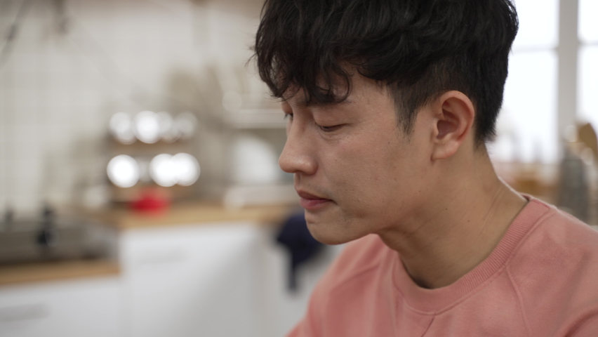 closeup shot of asian male making funny face expression while tasting spicy food at dining table. he eats lots of rice to make it less spicy Royalty-Free Stock Footage #1088946013
