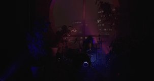 HDR video. Light turns on, the female drummer make a trick with drumsticks and begins to masterfully playing drums. Blue and red concert RGB spot lights flickering to the beat of the drums