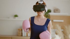 Virtual Metaverse Augmented Reality asian female adult working out boxing in VR headset aerobic training for boxing punch in virtual reality at living room home interior background