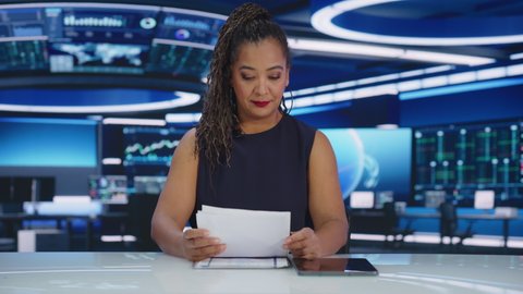 Beginning of TV Live News Program: Black Female Presenter Reading News Charismatically. Television Cable Channel Expressive Anchorwoman Talks. Mock-up Network Broadcasting Playback in Newsroom Studio