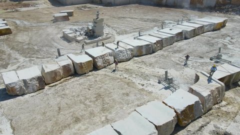 cutting marble blocks in a marble quarry. Workers are cutting large blocks of marble. aerial view drone shoot. marble mine