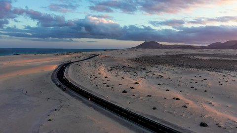 Winding road across the dunes of Corralejo, Fuerteventura, in the Canary Islands, Spain. Aerial view of road crossing Corralejo Dunes Natural Park, Fuerteventura, Canary Islands, Spain