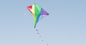 Video of multicoloured kite flying high on wind. childhood, freedom, fun and playing outdoors concept.