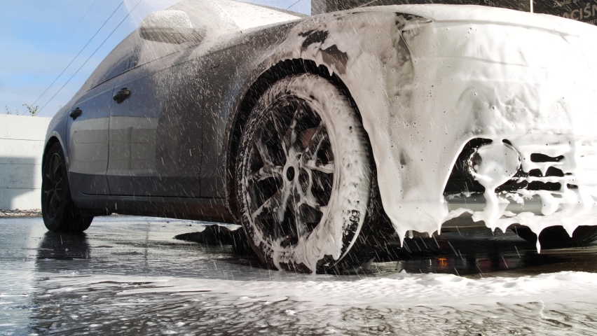 Washing luxury car on a touchless car wash. Washing sedan car with foam and a high pressure water. Spring cleaning in a car wash. | Shutterstock HD Video #1088956955