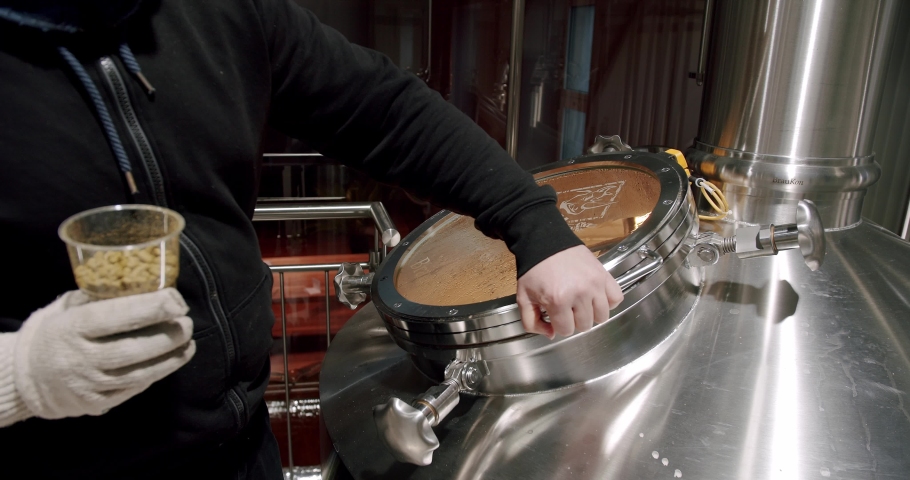 Pouring Malt Grains Into The Large Milling Tank In The Brewery. Beer making in craft brewery, Kettle with beer inside. Modern beer factory. Huge steel tanks for beer brewing. Royalty-Free Stock Footage #1088957003