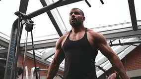 Afro american muscular man performs a workout in a crossover simulator - Powered by Shutterstock - Get 15% off with code: PIKWIZARD15