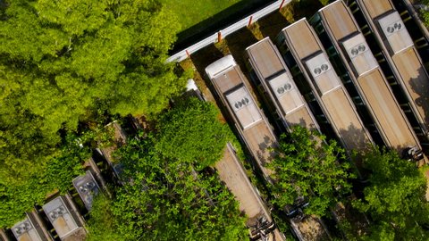 4K aerial footage of Train cemetery, abandoned old LRT locomotives trains lie on the ground.