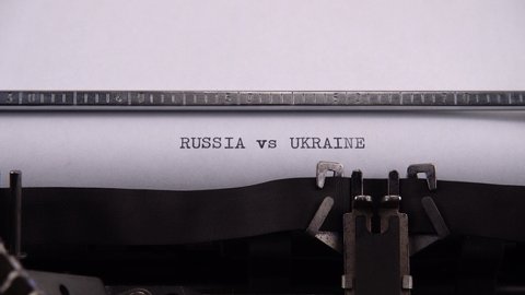 Typing phrase "RUSSIA vs UKRAINE" on retro typewriter.