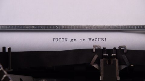 Typing phrase "PUTIN go to HAGUE !" on retro typewriter.