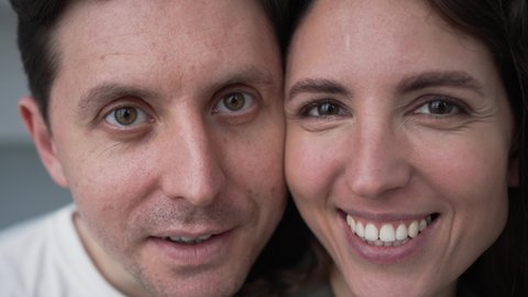 Close-up portrait of a married couple in love looking at the camera kissing and smiling