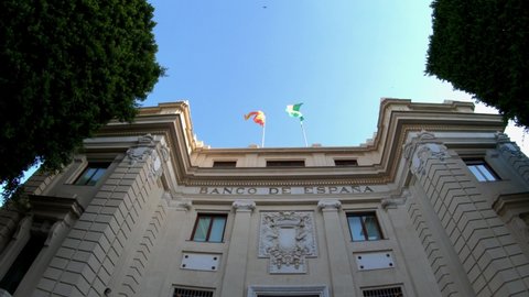 Seville, Spain, September 12, 2021: The façade of Banco de Espana (Bank of Spain) in the Plaza de San Francisco in Seville, the capital of Andalusia region in Southern Spain. Flags waving in the wind.