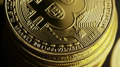 Golden colored real bitcoins rotating slowly with closeup