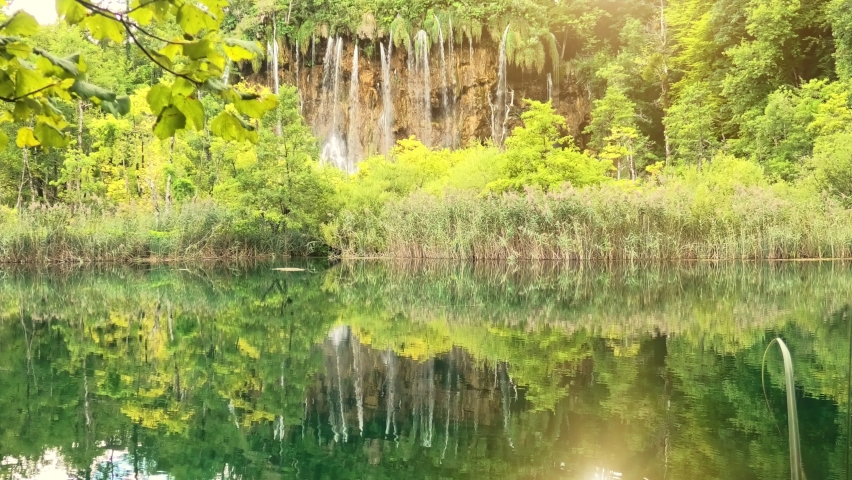 Plitvice National Park and sunshine in Croatia and Veliki Prstavac waterfall reflected in the lake. Plitvicka Jezera national park and UNESCO World Heritage of Croatia.