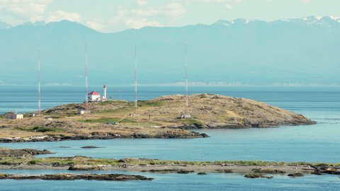 Trial Islands in the Salish Sea Victoria 4K UHD. The lighthouse on the Trial Islands, near Victoria on Vancouver Island. The Olympic Mountain range, in Washington State, is in the background. 4K. UHD.