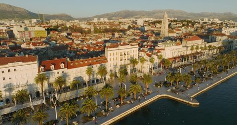 SPLIT, CROATIA - January 16 2022: Aerial shot of people walking along the Riva promenade and enjoying the coffee bars in the center of the old town in the Diocletian's Palace during sunset.
