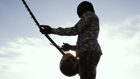 A Senegalese man plays a traditional kora string instrument. Traditional Afro African music often played in the streets, at weddings, and at festivals. 4k