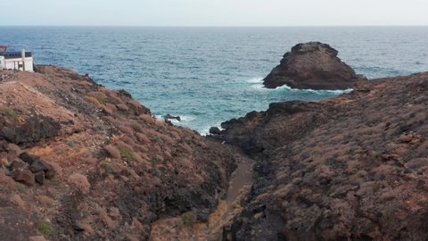 4K drone aerial shot of gorge Barranco de San Joaguin near Los Roques approaching volcanic islands Rogue Fuera and Atlantic Ocean in south Tenerife, Canary Islands