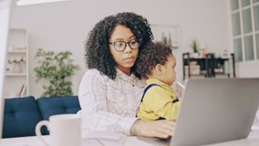 Tired African American woman working and babysitting son, unpaid maternity leave - Powered by Shutterstock - Get 15% off with code: PIKWIZARD15