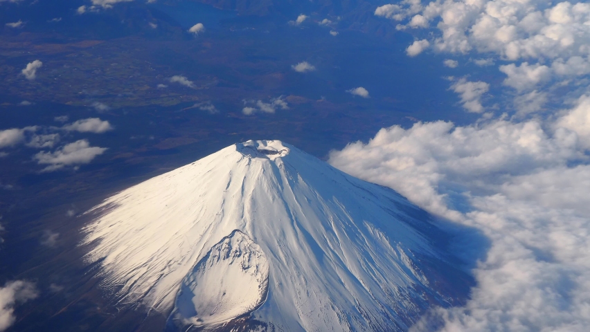 Top of Mt. Fuji.  Bird eyes view of big and high mountain Fuji of Japan. Mount Fuji Yama from sky above. Aerial view. With white snow on top and clouds around. Represent winter season of Japan.