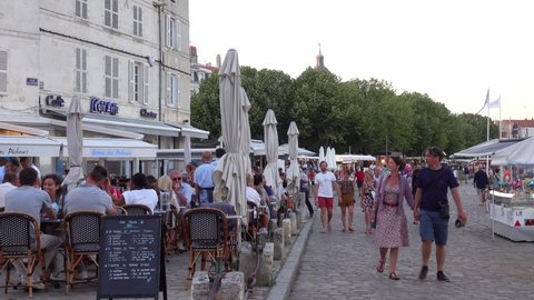 Terrace of a restaurant with people on the embankment in a European city. Europe, France, La Rochelle, July 19, 2021