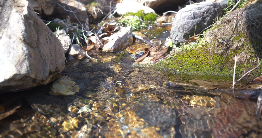 small water stream is flowing through rocky valley