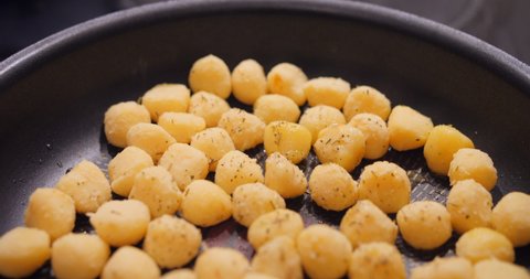 Gnocchi round shaped frying in a pan. Delicious homemade recipe from Italy.