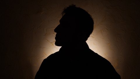Silhouette of unknown male person over dark 