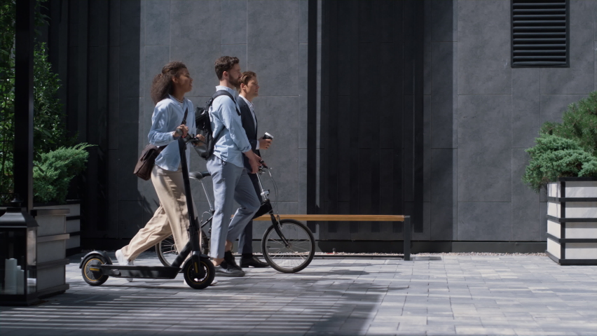 Two colleagues going downtown street talking. Shared eco-friendly transportation. Focused woman holding electric scooter commute to office with business man coworker with bicycle. Modern city mobility Royalty-Free Stock Footage #1088993329