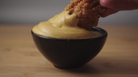 dipping fried chicken in mustard sauce