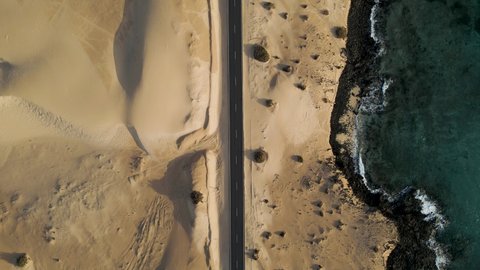 Aerial top down view of a road crossing the desert at Corralejo sand dunes natural park, Fuerteventura, Canary Islands, Spain.