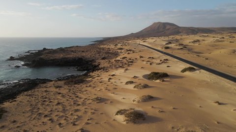 Aerial view of a road along the coast crossing the Sand Dune Natural Park in Corralejo, Fuerteventura, Canary Islands, Spain.