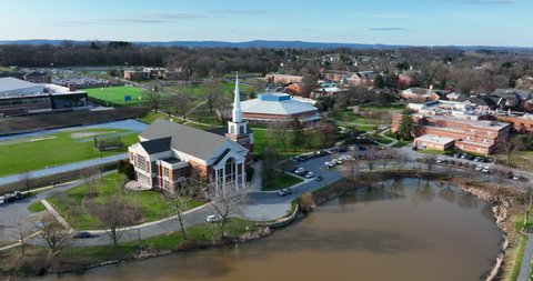 Elizabethtown Etown College. Aerial of lake pond and chapel. Establishing shot of university campus grounds.