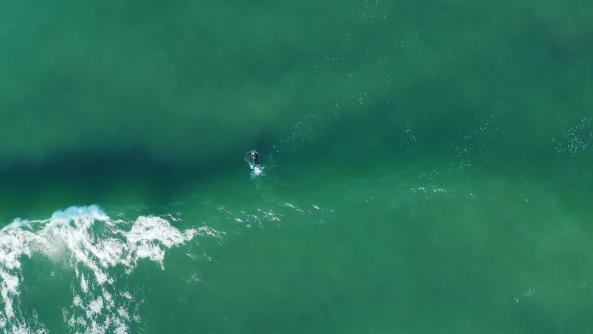 Surfer Over Tidal Waves Of Blouberg Sea In Cape Town, South Africa. Aerial Drone Shot