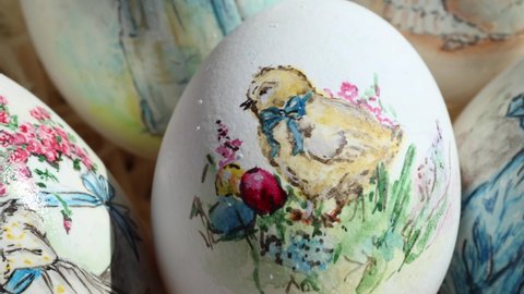 Close-up of different drawings on goose eggs for Easter festival. Eggs on hay. Hand made print. Spring hollidays. Easter concept