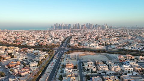Doha, Qatar: Aerial view of capital city of Qatar at sunset, cityscape with skyscraper skyline of West Bay site on horizon - landscape panorama of Arabian Peninsula from above, West Asia