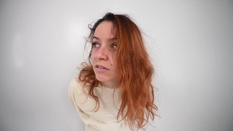 Close-up portrait of insane woman in straitjacket on white background.