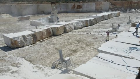 Workers are cutting large blocks of marble. Cutting marble blocks in a marble quarry. Aerial view drone shoot. marble mine